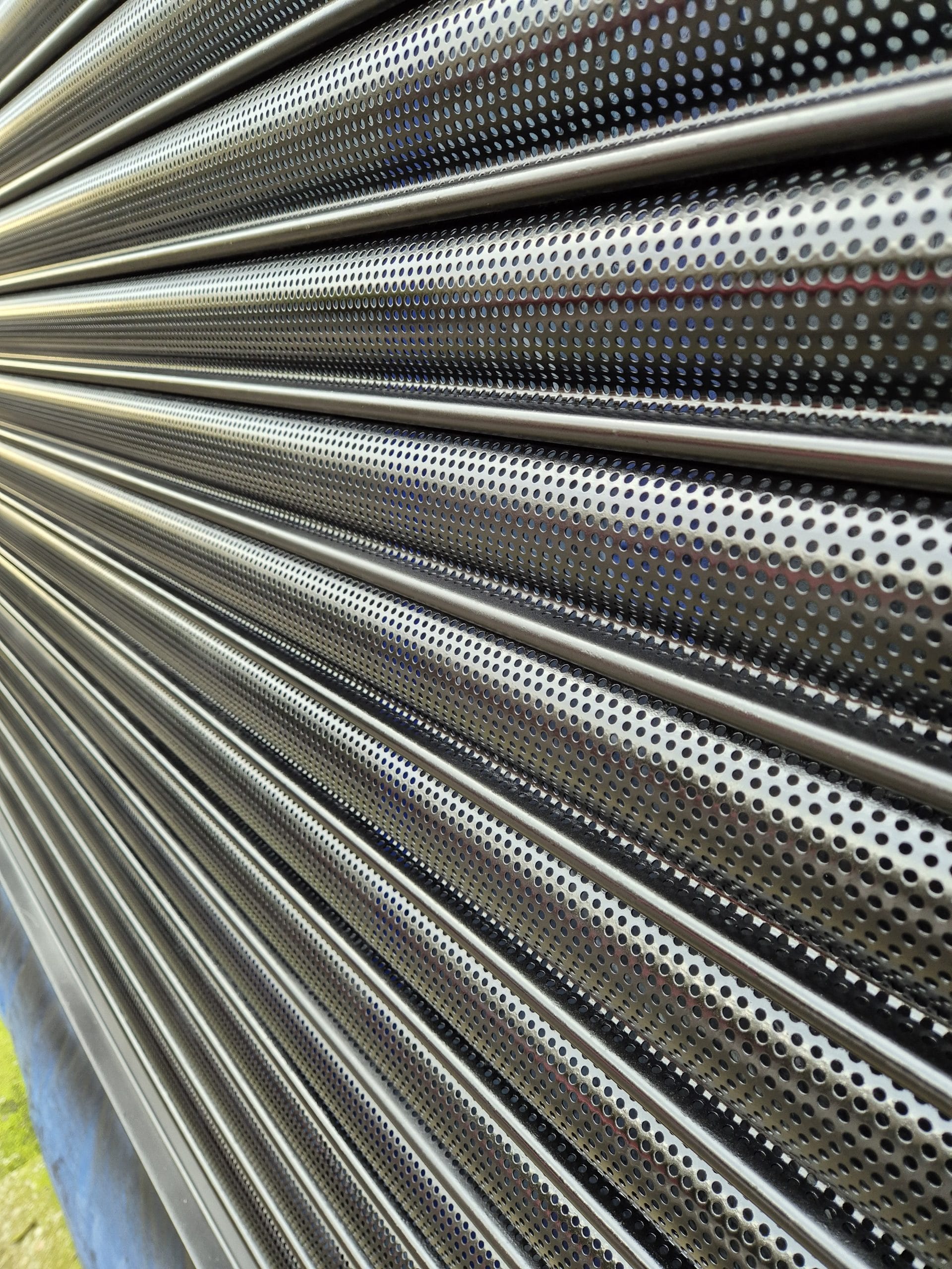 a metal perforated roller shutter that was sprayed in satin black ral 9005